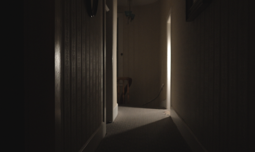 Dimly lit wooden hallway inside Mackay Mansion