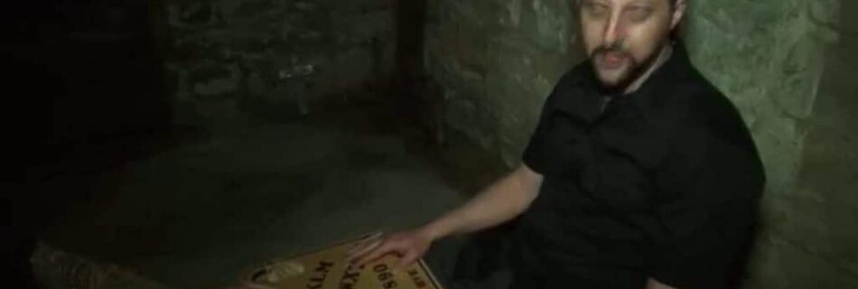 Investigator using a Ouija board during a LiveSciFi paranormal investigation