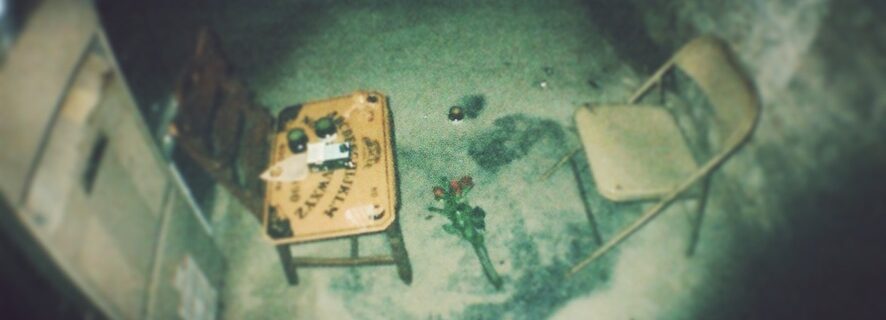Basement ghost hunt setup with Ouija board, chairs and investigation equipment photographed during a LiveSciFi investigation